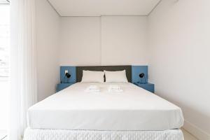 a bedroom with a large white bed with white sheets at WI-FI 200MB | Rooftop | Pool with Sea View #CA70D in Florianópolis +16 photos