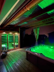 a hot tub on a deck with green lights at La Kaz 57 - Maison avec jacuzzi et sauna - La Réunion in La Plaine des Palmistes