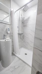a white bathroom with a shower and a toilet at Hotel Fuego Bronx near Yankee Stadium in Bronx