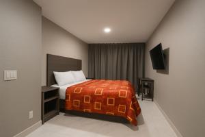 a bedroom with a bed and a television in it at Hotel Fuego Bronx near Yankee Stadium in Bronx