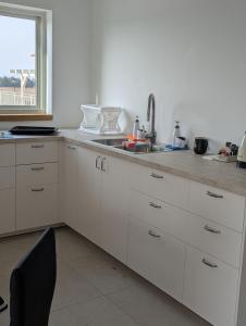 a kitchen with white cabinets and a sink and a window at הבית הכחול in Haspin