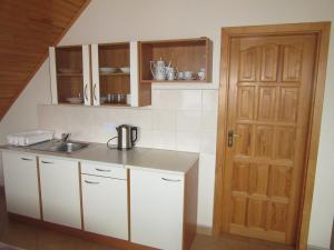 a kitchen with white cabinets and a sink and a door at Apartments Centrum in Liptovský Mikuláš +18 photos