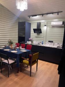 a dining room with a table and chairs and a counter at Хлеча house in Stantsiya Korchi