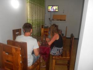 un hombre y una mujer sentados en una mesa en splendid lake view safari lodge, en Udawalawe