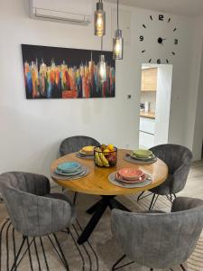 a dining room table with chairs and a clock on the wall at Lelo Sunset Spa, Romantic Garden Apartment with Private Jacuzzi in Zadar