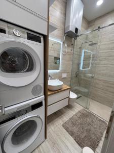 a bathroom with a washing machine and a shower at Lelo Sunset Spa, Romantic Garden Apartment with Private Jacuzzi in Zadar