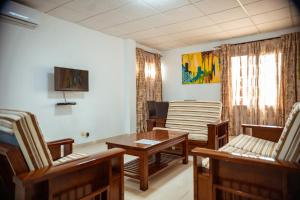 a living room with chairs and a table at Guest House Lumen in Lomé