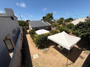 two white tents in a yard next to a building at Complejo Samaya in San Clemente del Tuyú