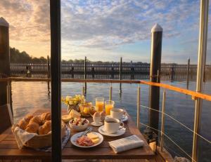 a breakfast table on a boat with a view of the water at ÖKO Budget Hausboot Retreat Morgenrot in Stralsund