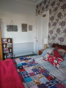 a bedroom with a bed with a quilt on it at 95 St Mary Street in Kirkcudbright