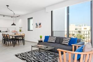a living room with a couch and a table at Luxury 3BR Sea View and Pool in Tel Aviv
