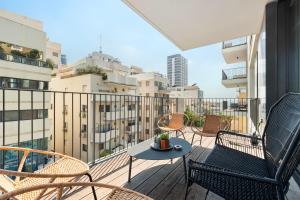 a patio with chairs and a table on a balcony at Luxury 3BR Sea View and Pool in Tel Aviv