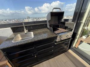 a kitchen with a sink and a grill with a view at 1B in Naco Jacuzzi very Centric in Santo Domingo