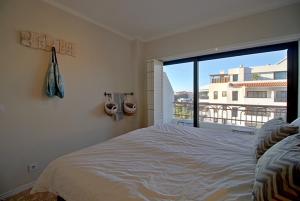 a bedroom with a large bed and a large window at Francisco Vau Apartment in Portimão