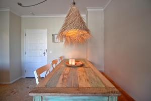 a room with a wooden table with chairs and a light at Francisco Vau Apartment in Portimão