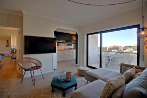 a living room with a couch and a table and a kitchen at Francisco Vau Apartment in Portimão