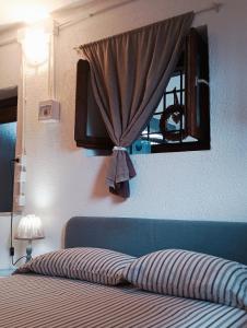a bedroom with a bed with a curtain and a window at Mountain Suite in Raveo