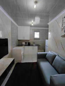 a living room with a couch and a kitchen at Mama R's Budget-friendly BACKROOM 3 in Newcastle