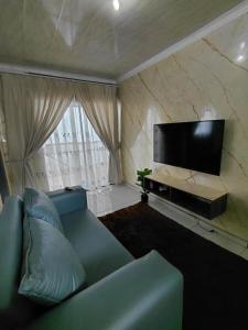 a living room with a couch and a flat screen tv at Mama R's Budget-friendly BACKROOM 3 in Newcastle