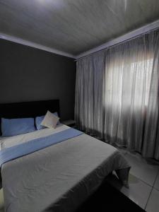 a bedroom with a large bed and a window at Mama R's Budget-friendly BACKROOM 3 in Newcastle