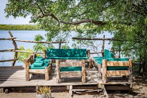 three chairs and a table and chairs on a dock at Keur Saloum Resort in Toubakouta +37 photos