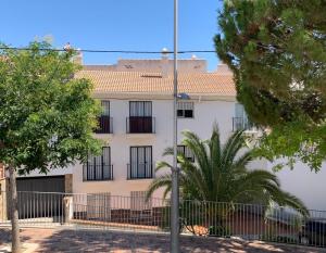 a white building with black windows and a fence at One bedroom penthouse in Alora