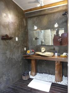 a bathroom with a wooden counter and a mirror at Pousada O Refúgio in Jericoacoara +34 photos