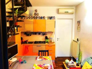 a kitchen with orange cabinets and a desk with a computer at Loft Bovisa in Milan