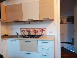 a kitchen with white cabinets and a stove top oven at Loft Bovisa in Milan