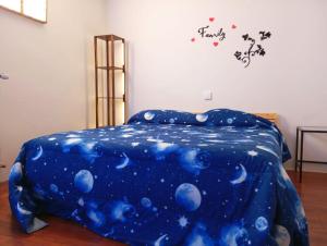 a bed with a blue comforter with the words happy on it at Loft Bovisa in Milan