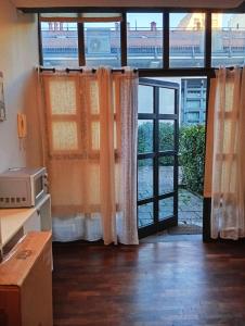 a room with a window with curtains and a microwave at Loft Bovisa in Milan