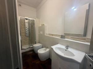 a white bathroom with a sink and a toilet at Garden suite / del ducato in Parma +23 photos