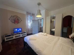 a bedroom with a large white bed and a television at Garden suite / del ducato in Parma