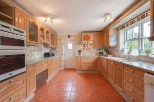 a large kitchen with wooden cabinets and appliances at 3 Bed in Wangford oc-frs in Wangford