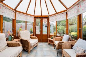 a screened in porch with wicker chairs and windows at 3 Bed in Wangford oc-frs in Wangford +2 photos