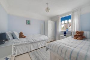 a bedroom with two beds and a teddy bear sitting on the bed at 3 Bed in Wangford oc-frs in Wangford