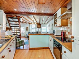 a kitchen with white cabinets and a wooden ceiling at 2 Bed in Keswick oc-sz145 in Braithwaite +8 photos