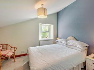 a bedroom with a white bed and a window at 2 Bed in Keswick oc-sz145 in Braithwaite