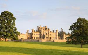 a castle in a field with trees in the foreground at 3 Bed in Penrith oc-sz390 in Shap