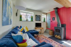 a living room with a blue couch and a fireplace at 2 Bed in Field Dalling oc-1988 in Saxlingham
