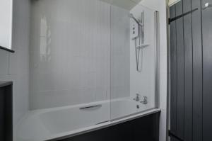 a white bathroom with a shower and a tub at 2 Bed in Field Dalling oc-1988 in Saxlingham +8 photos