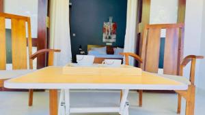 a table and chairs in a room with a bed at Villa 188 Yala in Tissamaharama