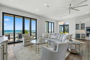 a living room with a couch and chairs and the ocean at Honeysuckle Blue in Pensacola Beach