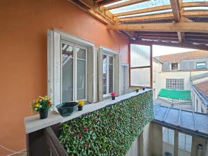 a balcony with windows and flowers on a building at Le Grand Bleu in Troyes