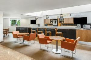a restaurant with tables and chairs and a bar at Fiesta Inn Express Puebla Finsa in Puebla