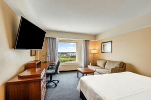 a hotel room with a bed and a desk with a television at Fiesta Inn Express Puebla Finsa in Puebla