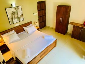 a large bedroom with a large bed with white sheets at Villa 188 Yala in Tissamaharama