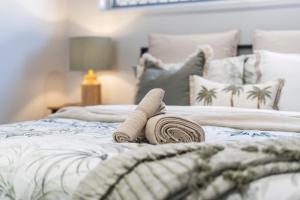 a bed with two rolled up towels on it at JOT Luxe Haven in Narangba
