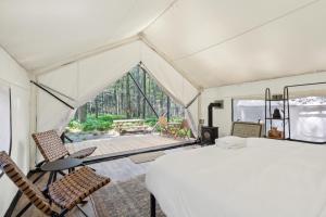 a room with a bed and chairs in a tent at Ferncrest Campground in Greentown