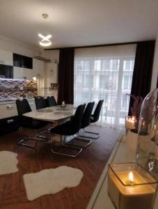 a dining room with a table and black chairs at Yoa Apartaments in Floreşti